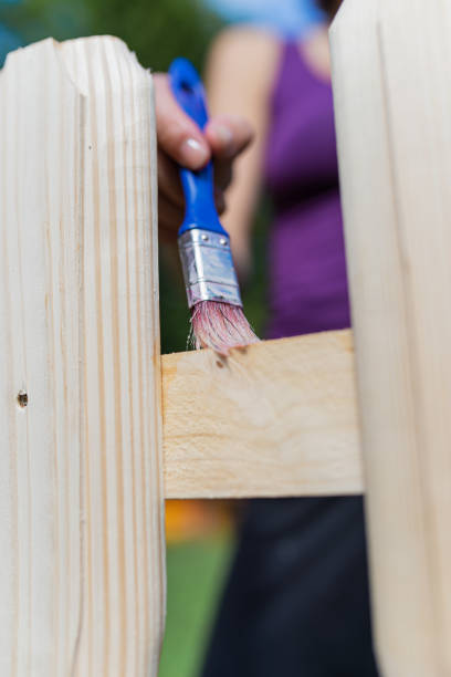 istock Applying transparent protective varnish on wooden fence 1221336113