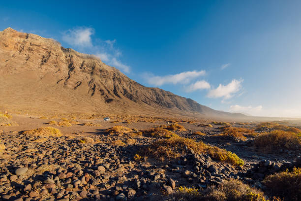 Famara beach, scenic landscape with plants and mountains in Lanzarote, Canary islands Famara beach, scenic landscape with plants and mountains in Lanzarote, Canary islands caleta de famara lanzarote stock pictures, royalty-free photos & images