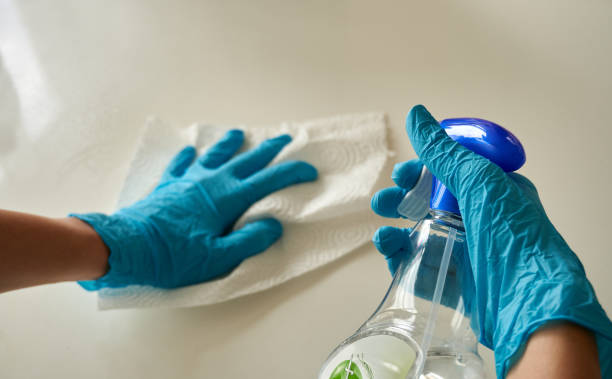 istock Human hands wearing blue disposable glove cleaning white surface in the kitchen 1221336573