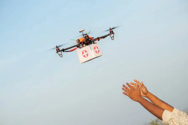 Photo of Drone Delivering First Aid Box or medicine to costumer hand during covid-19 or coronavirus lockdown - Advancing Medical Industry Logistics for Drug Transport concept.