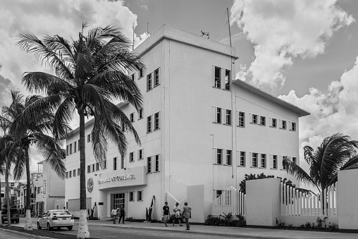 Cozumel, Mexico - April 24, 2019: Street view at day with pedestrians near Cozumel Naval Sector building in Cozumel, Mexico. Black and white photography.