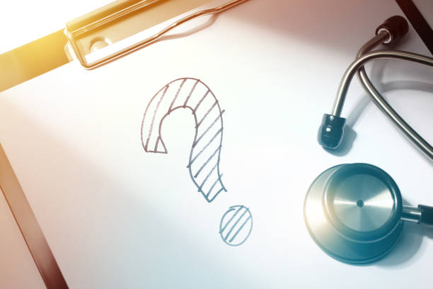 istock Diagnose Solution Close-up of Question Mark Drawing and Stethoscope on Doctors Medical Report Clipboard 1221342266