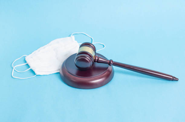 Judicial gavel and protective medical mask on a blue background. Concept of illegal resale of protection masks and over-resale during the coronavirus pandemic Judicial gavel and protective medical mask on a blue background. Concept of illegal resale of protection masks and over-resale during the coronavirus pandemic, danger markup stock pictures, royalty-free photos & images