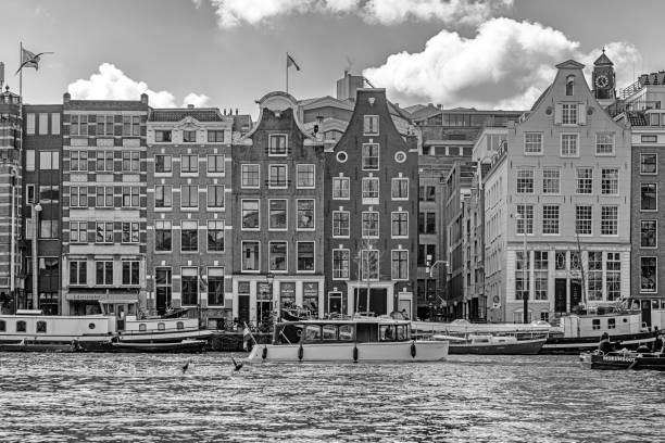 Amsterdam, Netherlands - April, 2019: Amsterdam canal houses in the canal district, there are people in the front of the houses.