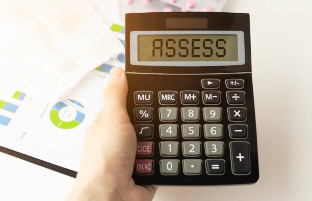 istock A calculator with the inscription ASSESS is placed in the stack of documents. Business concept 1221344302