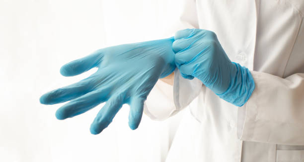 istock Doctor putting on protective gloves, isolated on white 1221344320