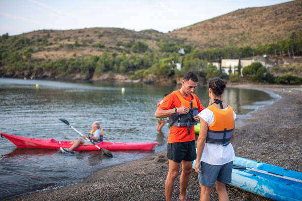 зрелый мужчина kayaker надевая спасательный жилет - women kayaking life jacket kayak стоковые фото и изображения