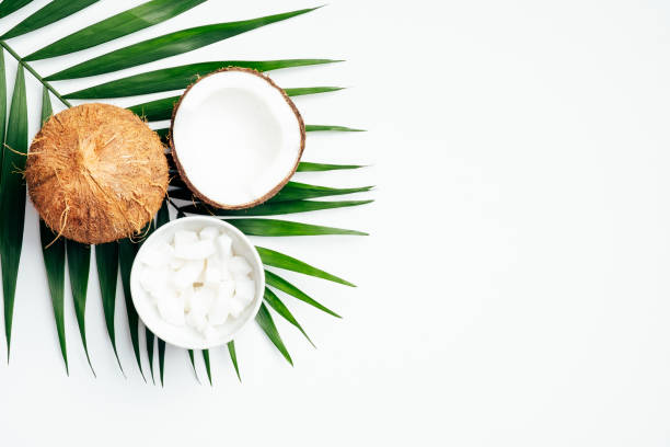 istock Coconut fruit with half and coconut flakes in bowl, tropical palm leaf on white background. Flat lay, top view. Summer background. 1221346075