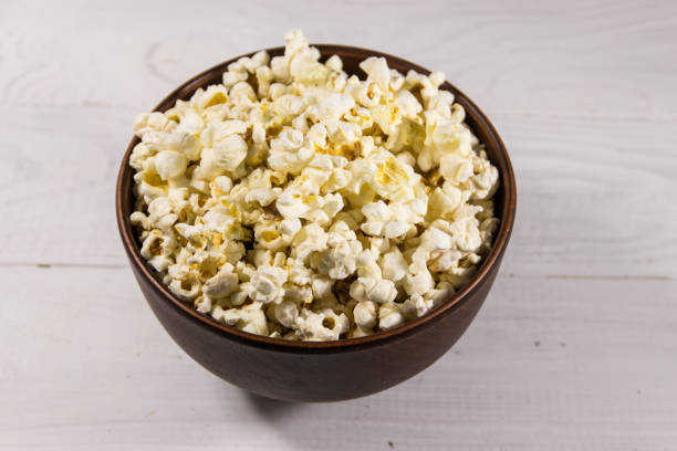 istock Bowl with popcorn on wooden table 1221346095