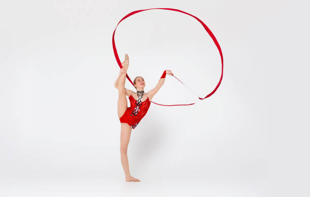 istock Attractive gymnast with ribbon getting ready for professional competition, white background 1221346458