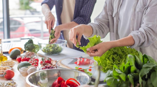 istock Millennial couple preparing healthy vegetarian salad enjoying process 1221347086