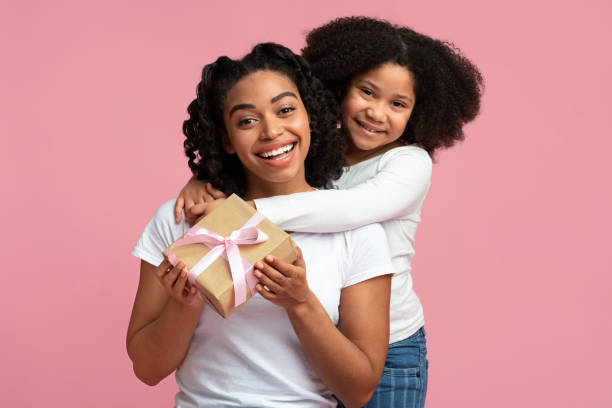 happy black woman received gift from her adorable little daughter - mother gift imagens e fotografias de stock
