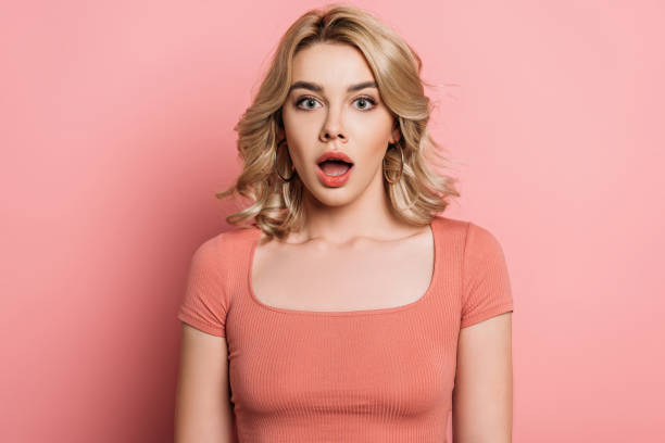 istock shocked girl looking at camera while standing with open mouth on pink background 1221347958