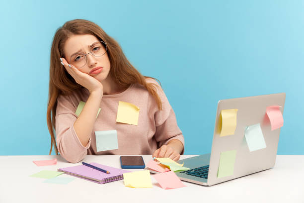 istock Exhausted overworked woman in nerd glasses sitting covered with sticky notes, looking with bored sleepy expression 1221348325