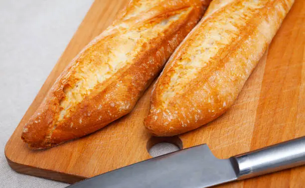 Photo of French loaves on wooden surface