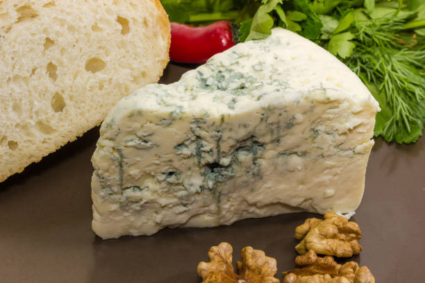 istock Piece of blue cheese with blue-grey mold on dish 1221350275