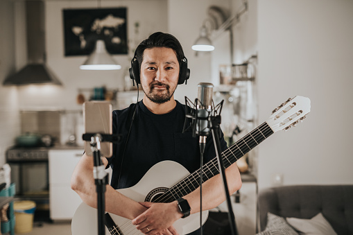 Retrato de un guitarrista japonés en casa estudio photo