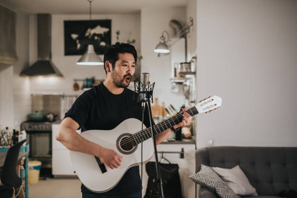 istock Japanese man practices guitar playing at home 1221351565
