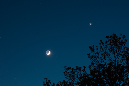 Beautiful night image of a sickle moon and planet Venus close together.