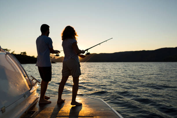 istock A Young Couple Fishing at Sunset, 1221355399