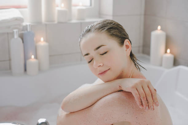 istock A young beautiful woman uses a body srab in a bath. 1221359413