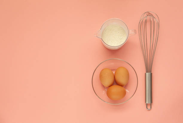 istock Whisk and a plastic cup for whipping on a pink background. 1221360263