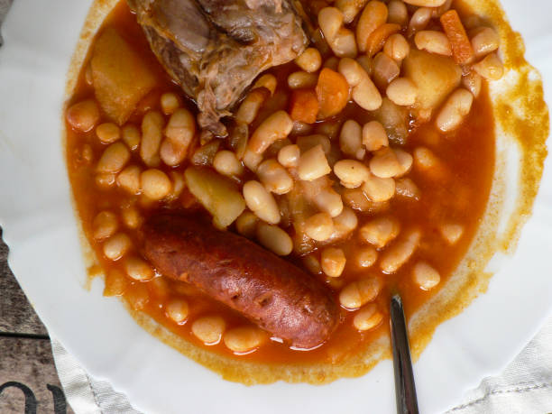 istock Spanish Asturian fabada in a white plate, spoon on wooden table 1221360629