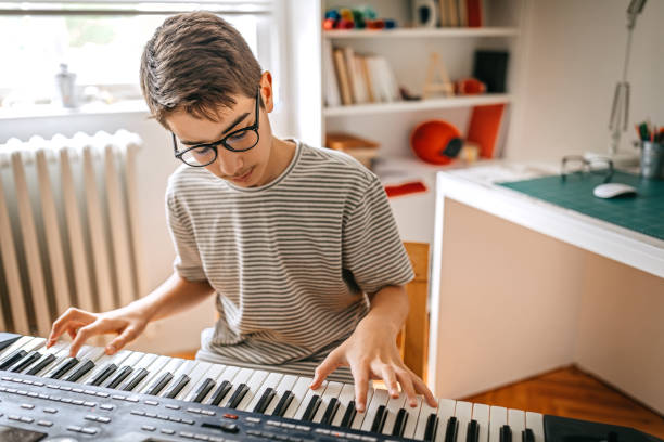 istock Teenage boy playing the keyboard 1221360953