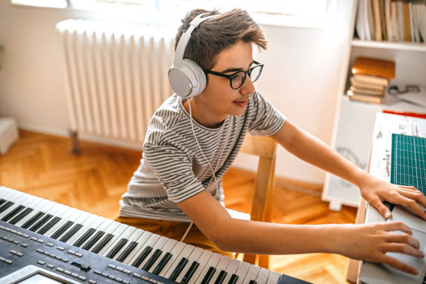 istock Teenage boy having online keyboard lesson 1221361186