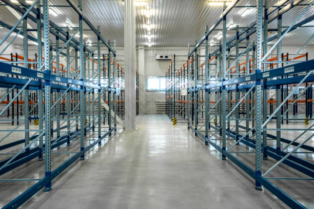 istock Perspective of Blue warehouse shelves in grey interior. Blue storage warehouse. Empty warehouse shelves in grey interior 1221362437