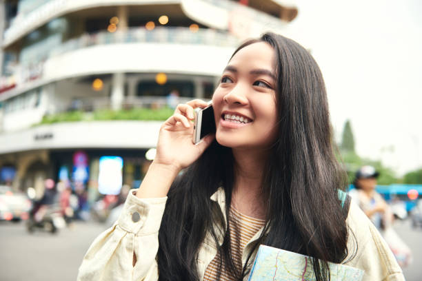 istock Asian woman calling and holding a paper map 1221362842