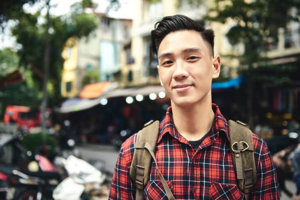 portrait of young tourist with backpack in the city - etnia vietnamita imagens e fotografias de stock