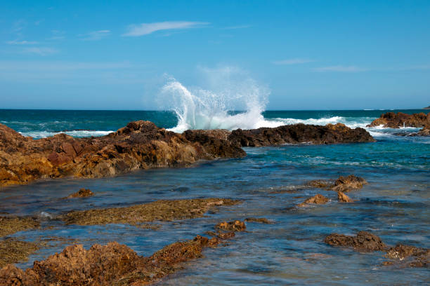 вид с пляжа горизонта и волны, разбиваемые над скалистыми обнажениями - tomakin стоковые фото и изображения