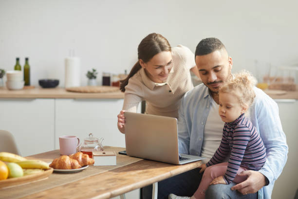 istock Modern Family Using Laptop with Cute Little Daughter 1221368536