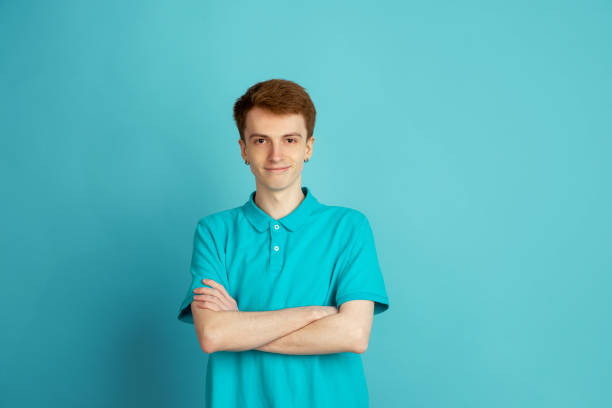 istock Caucasian young man's monochrome portrait on blue studio background, emotinal and beautiful 1221369783
