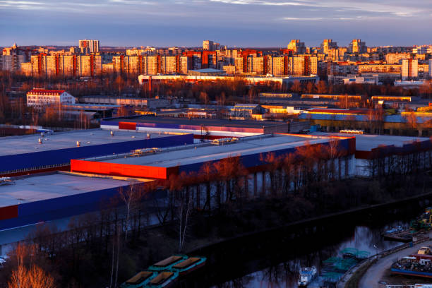 photographie aérienne du soir quartier industriel d’une grande ville russe avec des entrepôts, des entrepôts, des bureaux et des bâtiments. beau ciel au coucher du soleil. - factory night skyline sky photos et images de collection