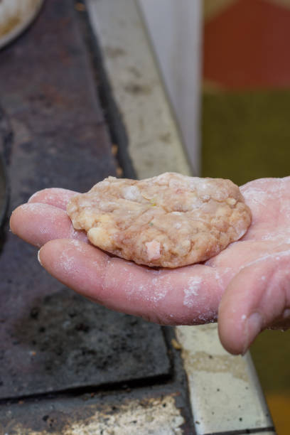 istock Grandmothers hand holding minced meat burger 1221371552