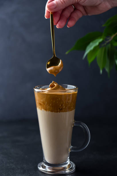 istock Making dalgona coffee. Hand with a spoon of whipped foam 1221371569