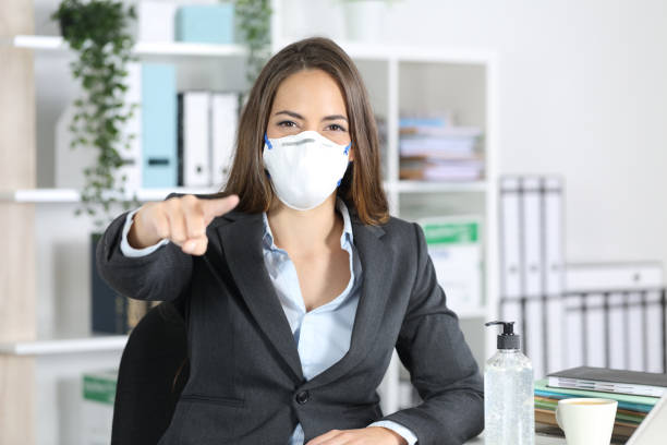 istock Executive with mask pointing at you at office 1221372909