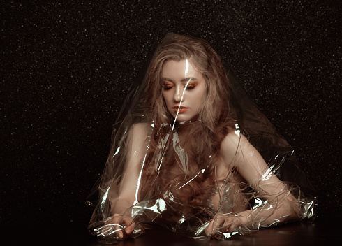 Blond girl caught in plastic wrap... feeling isolated and lonely