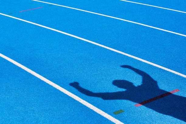 Shadow of an athlete celebrating success in finish line Shadow of an athlete celebrating success in finish line finish line stock pictures, royalty-free photos & images