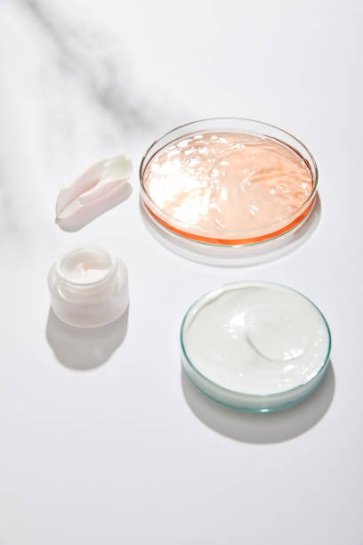 istock Laboratory glassware with cosmetic cream and liquid and rose leaf on white background with shadow 1221381121