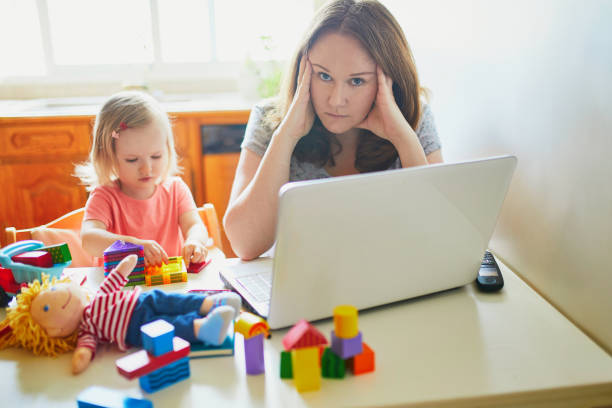 istock Exhausted and stressed mother working from home with toddler 1221387457