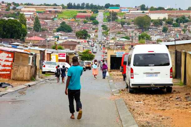 African people walking down a main road in Alexandra township, a formal and informal settlement Johannesburg, South Africa - January 17, 2011: African people walking down a main road in Alexandra township, a formal and informal settlement alexandra township photos stock pictures, royalty-free photos & images