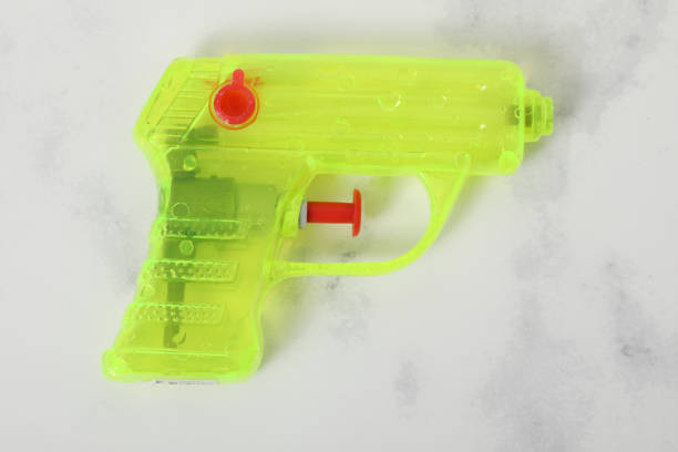 Shot of a father and son playing with squirt guns at home.