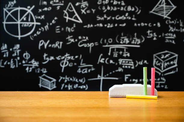 istock Education background concept. Board eraser and chalk on the wooden table with blackboard with many Mathematical formula. 1221390376