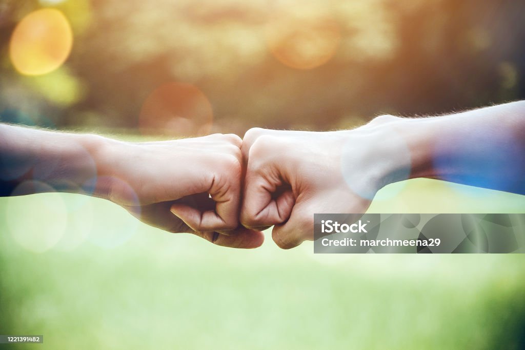 Hands of two man people fist bump team teamwork and partnership business success. Volunteer charity work. People joining for cooperation mergers and acquisitions concept Togetherness Stock Photo