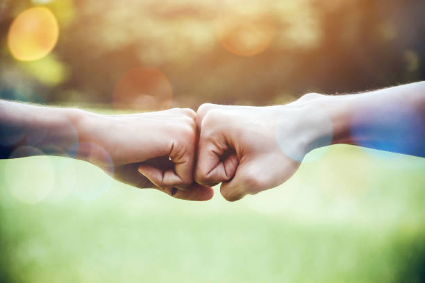 hands of two man people fist bump team teamwork and partnership business success. volunteer charity work. people joining for cooperation mergers and acquisitions concept - confiança imagens e fotografias de stock