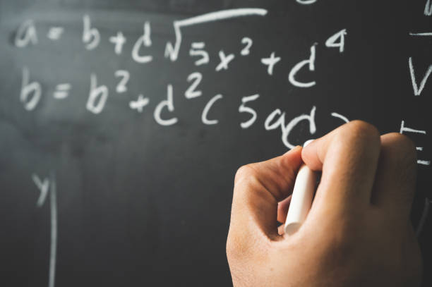 istock Education background concept. Close up male hand writing mathematical formula on chalkboard. 1221391960