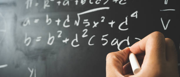 istock Education background concept. Close up male hand writing mathematical formula on chalkboard. 1221392108